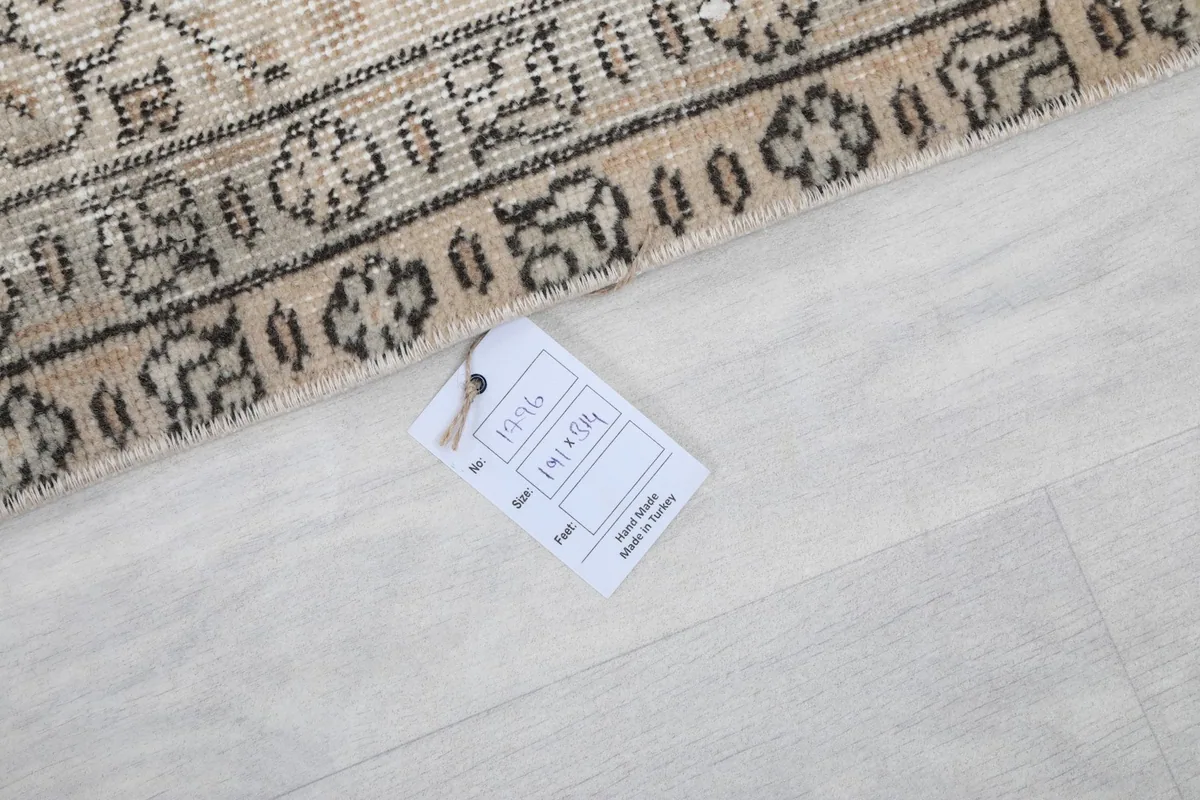 Care tag displaying the rug's dimensions and origin, placed on the rug