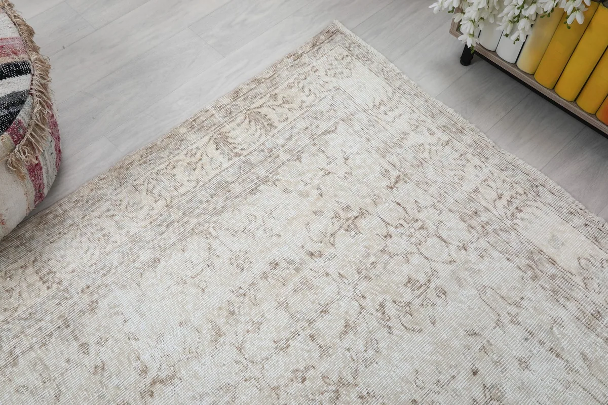 Corner view of the rug, illustrating the soft blend of beige and tan tones.