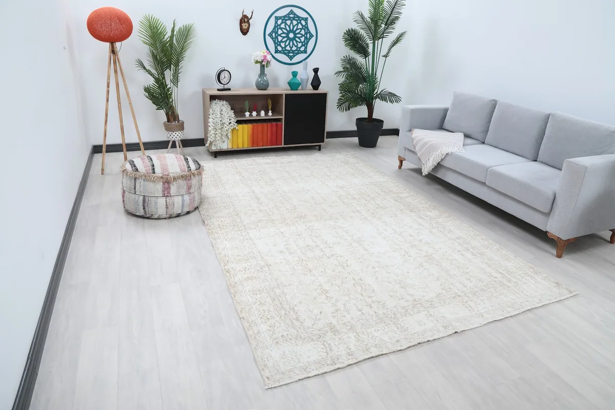 Wide shot of the beige vintage rug in a living space, showing its scale.