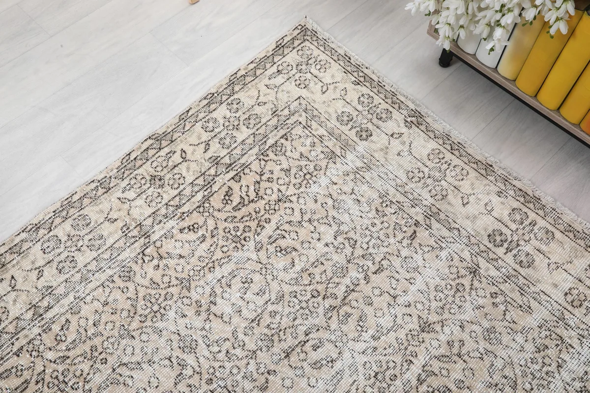 Corner view of the rug showing the subtle wear and patina on the gray pattern