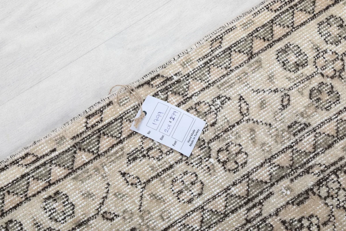 Detail of the rug's edge with a size label showing '6'7" x 9'10"' dimensions