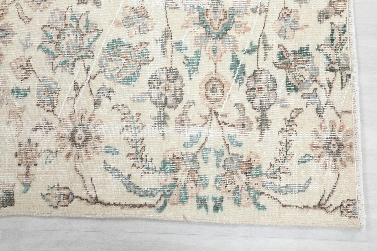 Detailed view of the hand-knotted wool pile and intricate botanical patterns in blue and tan