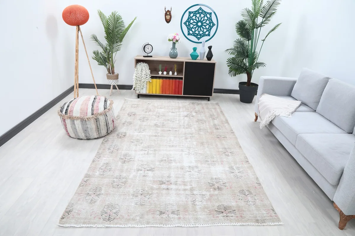 Ivory vintage rug displayed in a modern living room setting with plants and a couch