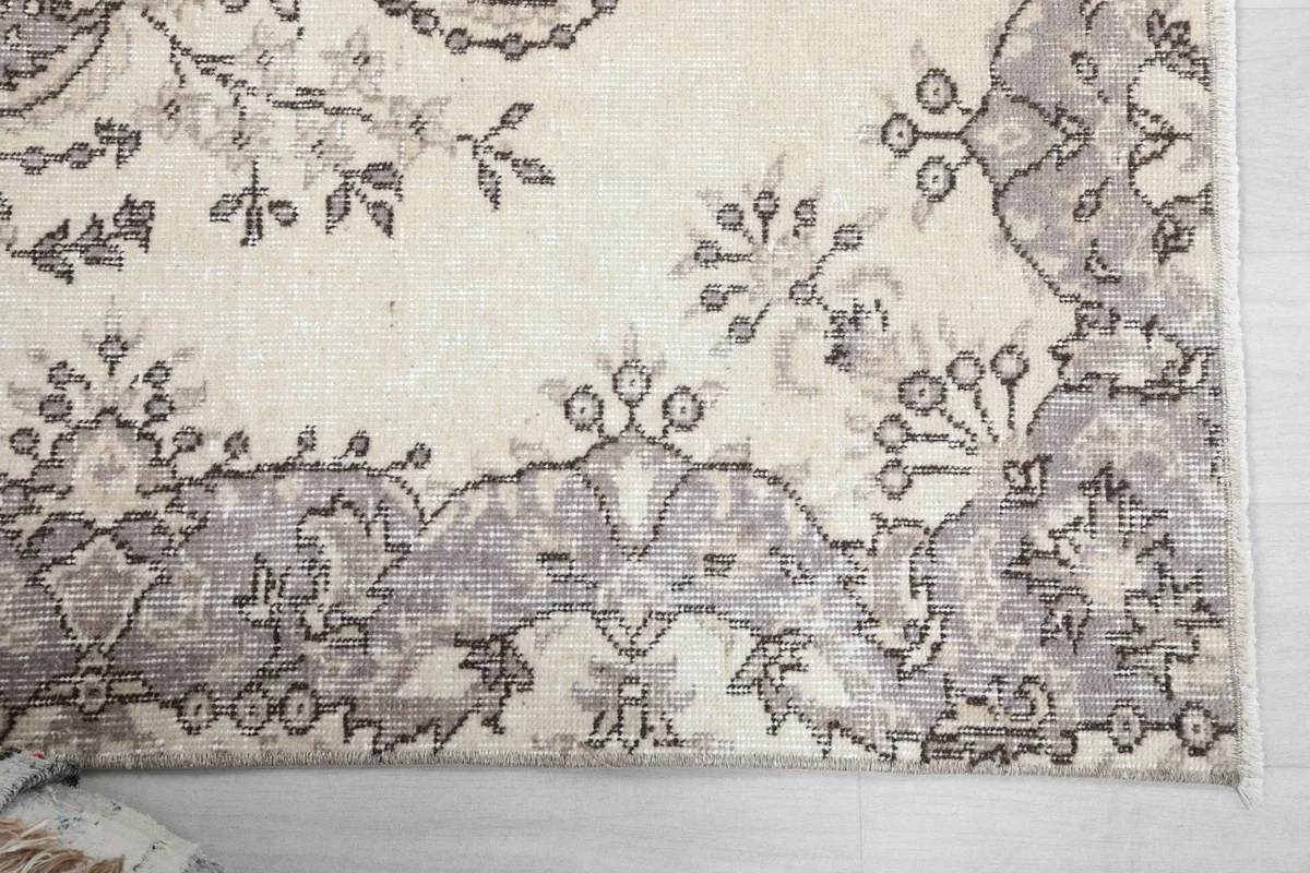 Detail of the gray border pattern and the corner of the vintage rug