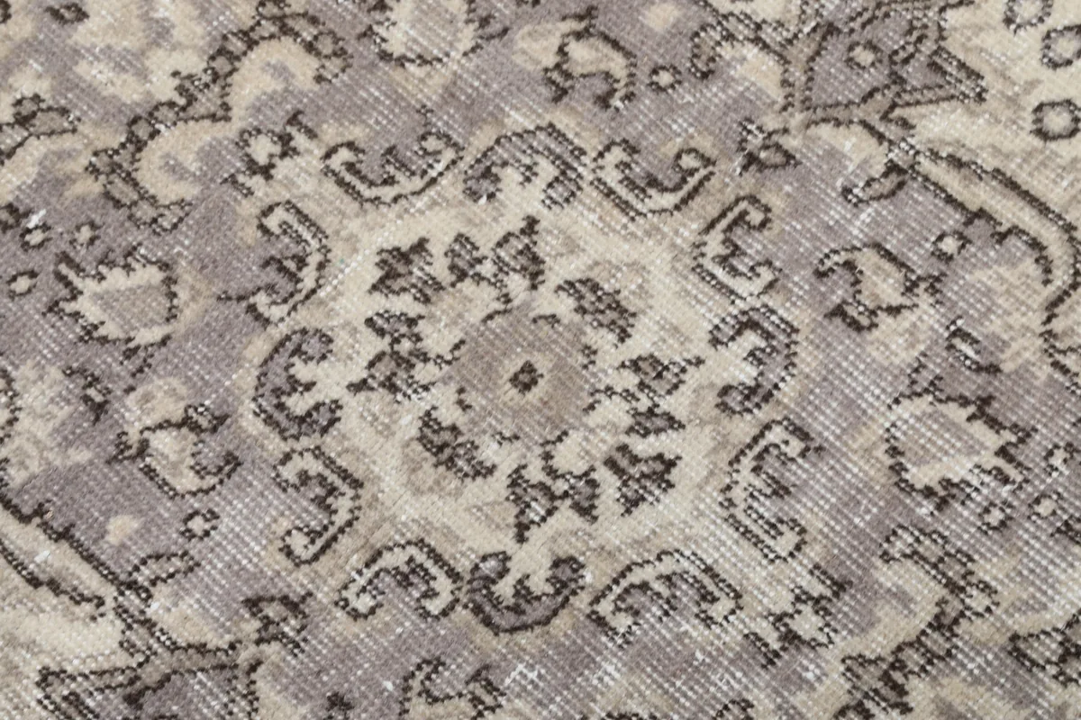 Close-up showing the texture of the wool pile and subtle color variations in the gray medallion