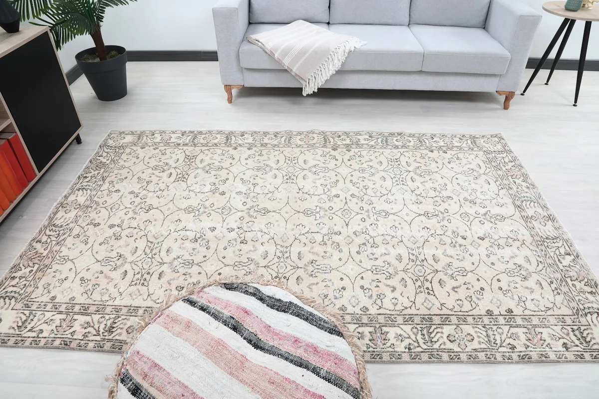 Wide shot of the beige Anatolian rug laid out in a room, offering a sense of scale and design.