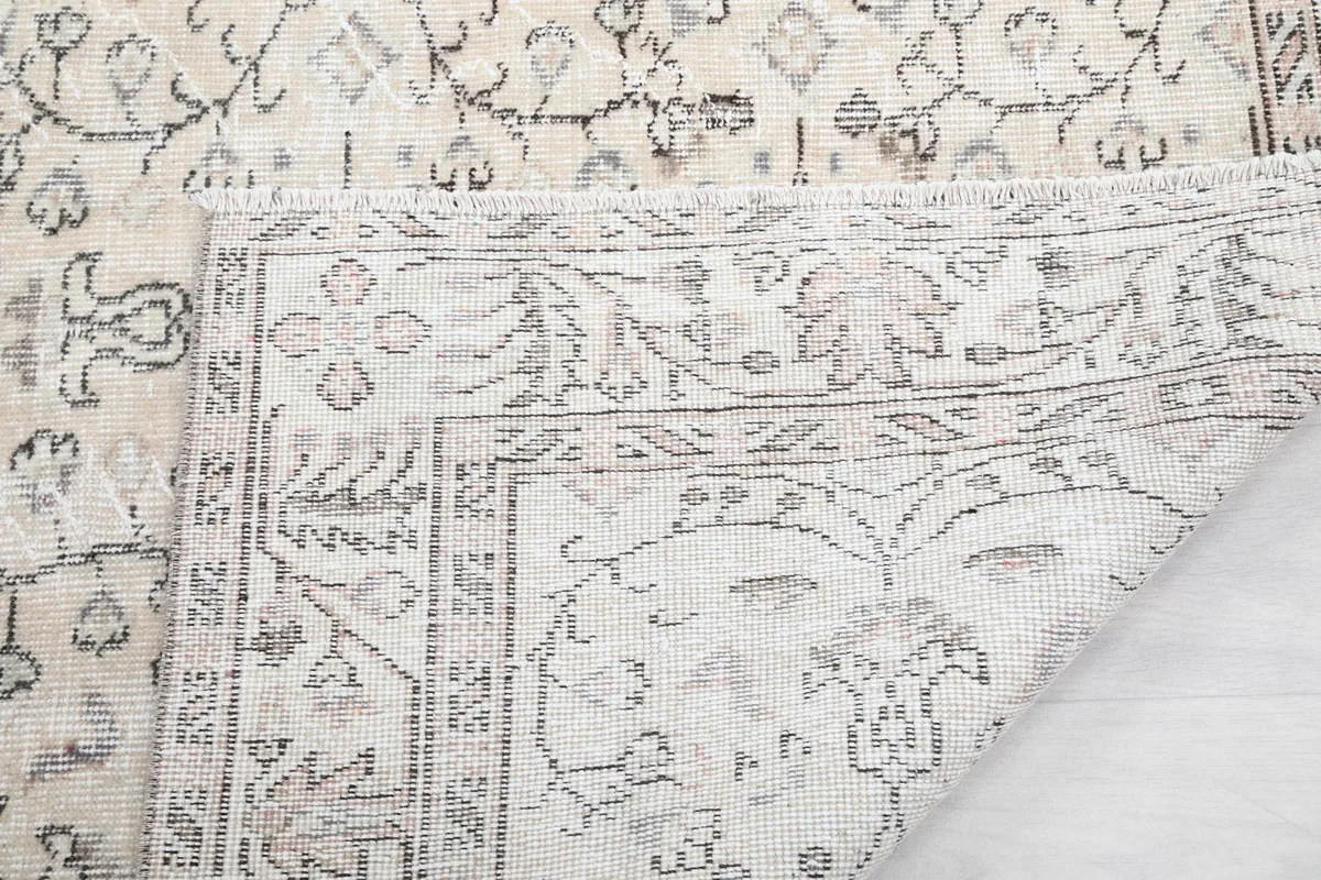 Close-up of the rug's backside, showing the tight hand-knotting and fringe detail.