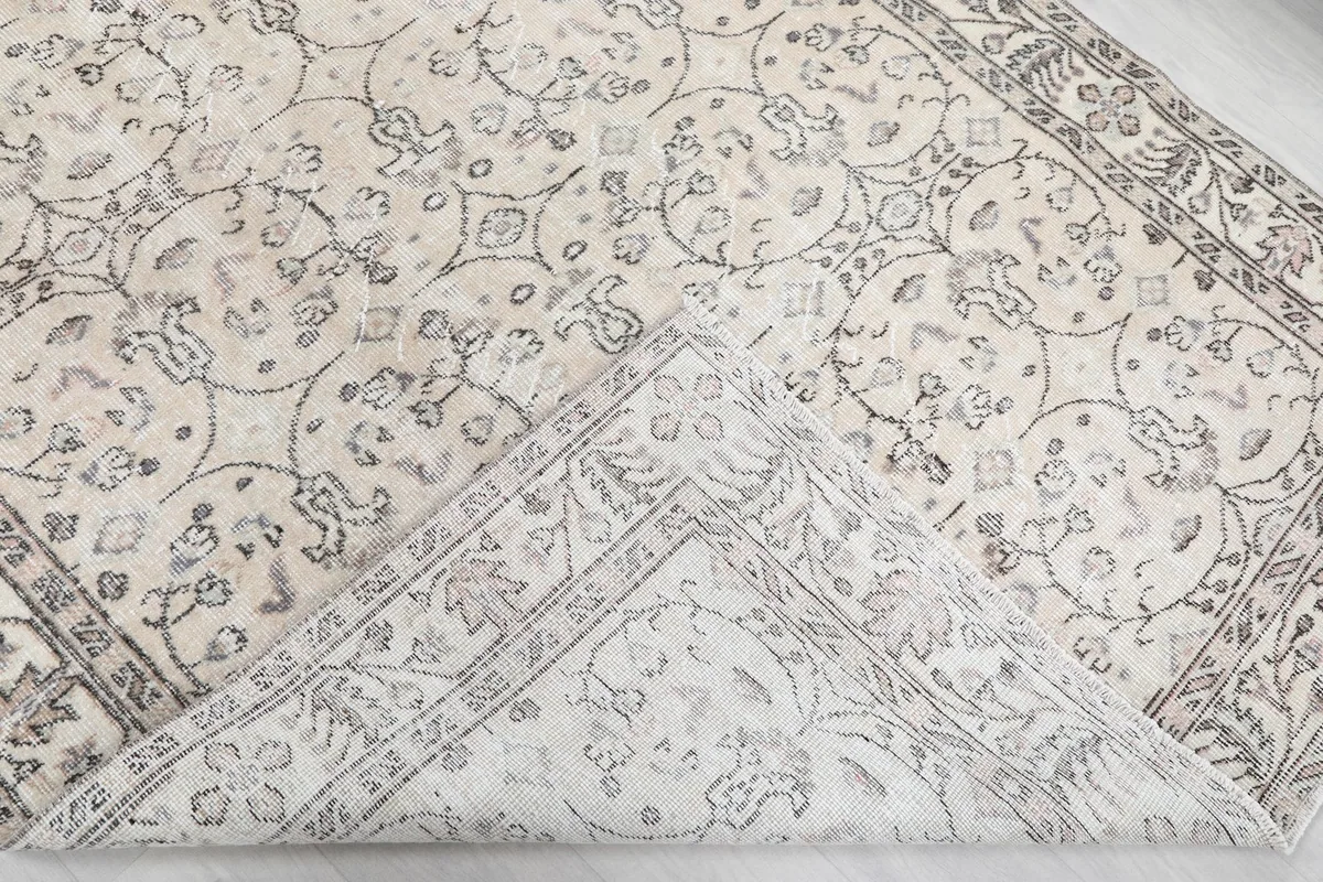 View of the rug folded back to reveal the cotton foundation and reverse side of the knots.