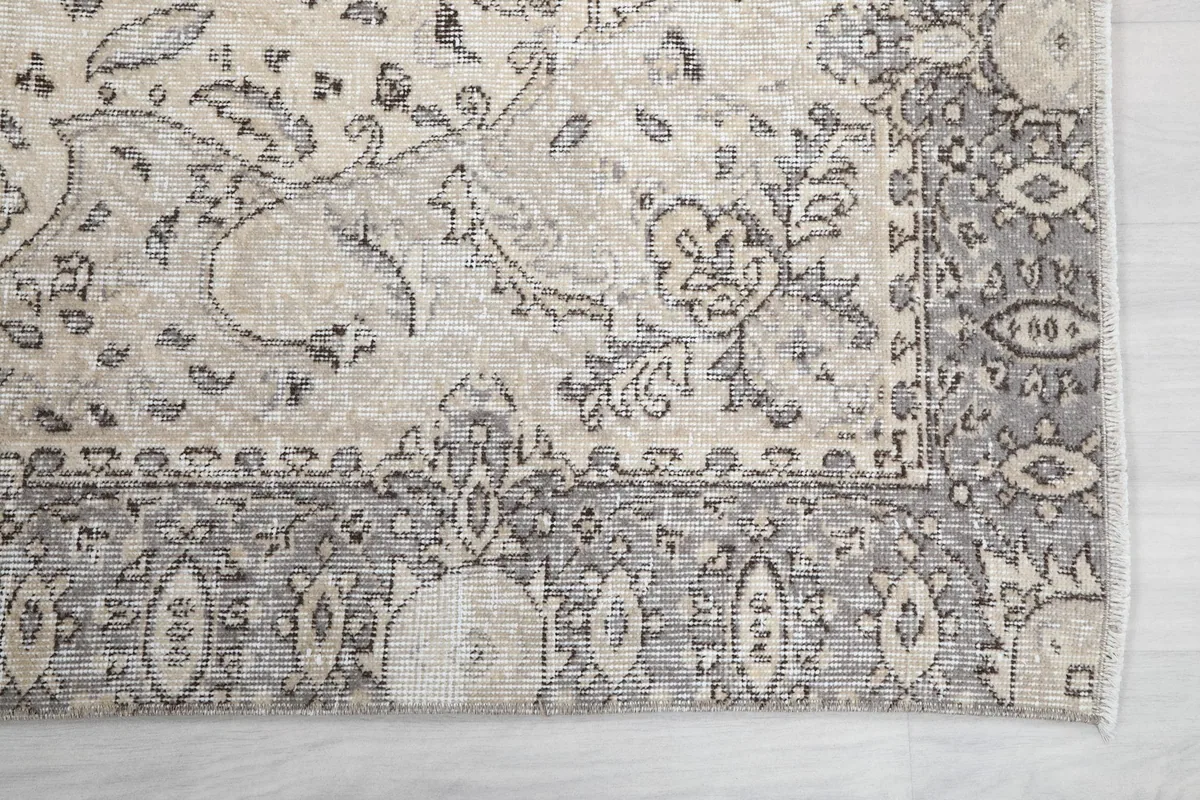 Detail of the rug's gray border design with geometric and floral elements