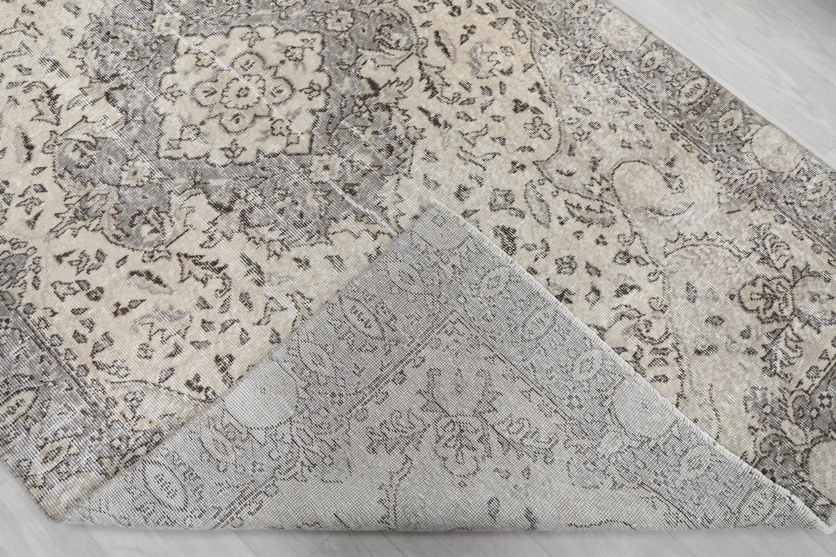 Corner of the rug folded back to reveal the hand-knotted cotton foundation