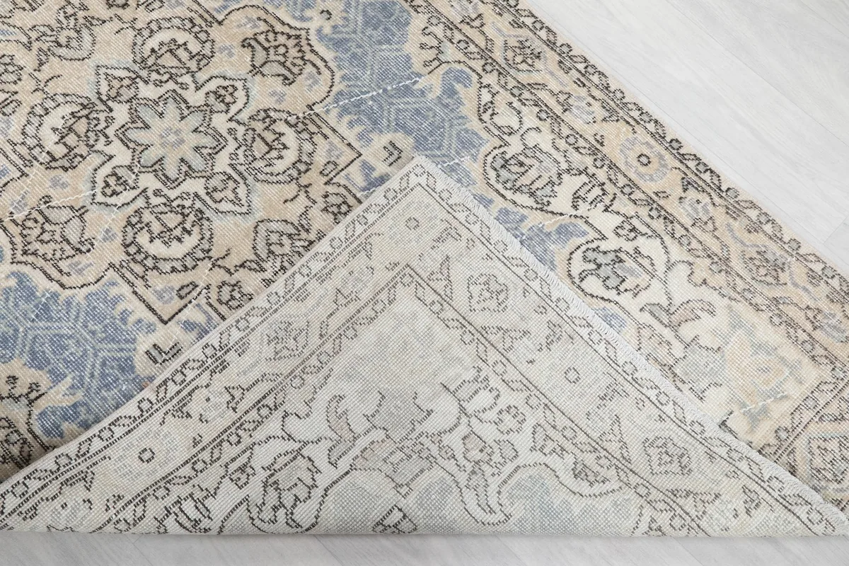 View of the back of the rug, showing the cotton foundation and hand-knotted construction