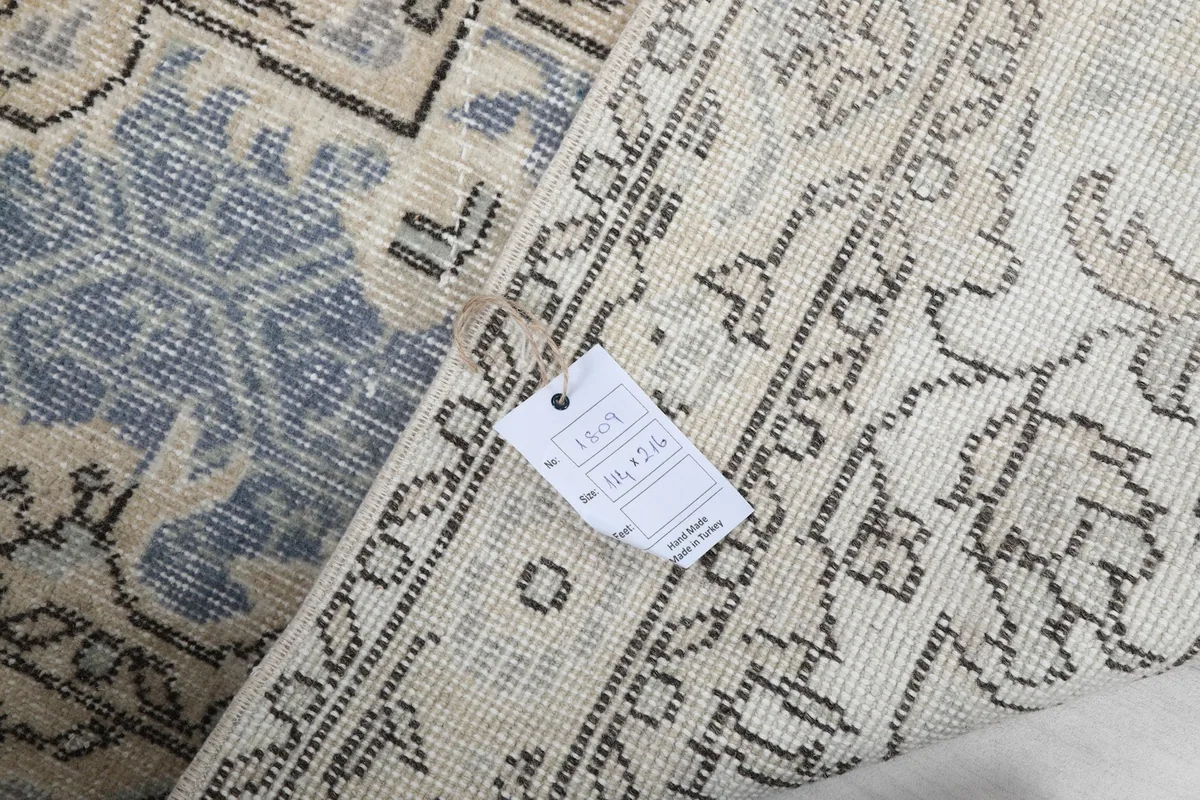 Detail of the rug's back with a product tag, indicating its origin and materials