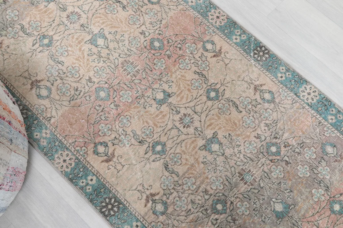 Overhead angle shot of the runner rug's floral and geometric motifs from a diagonal perspective.
