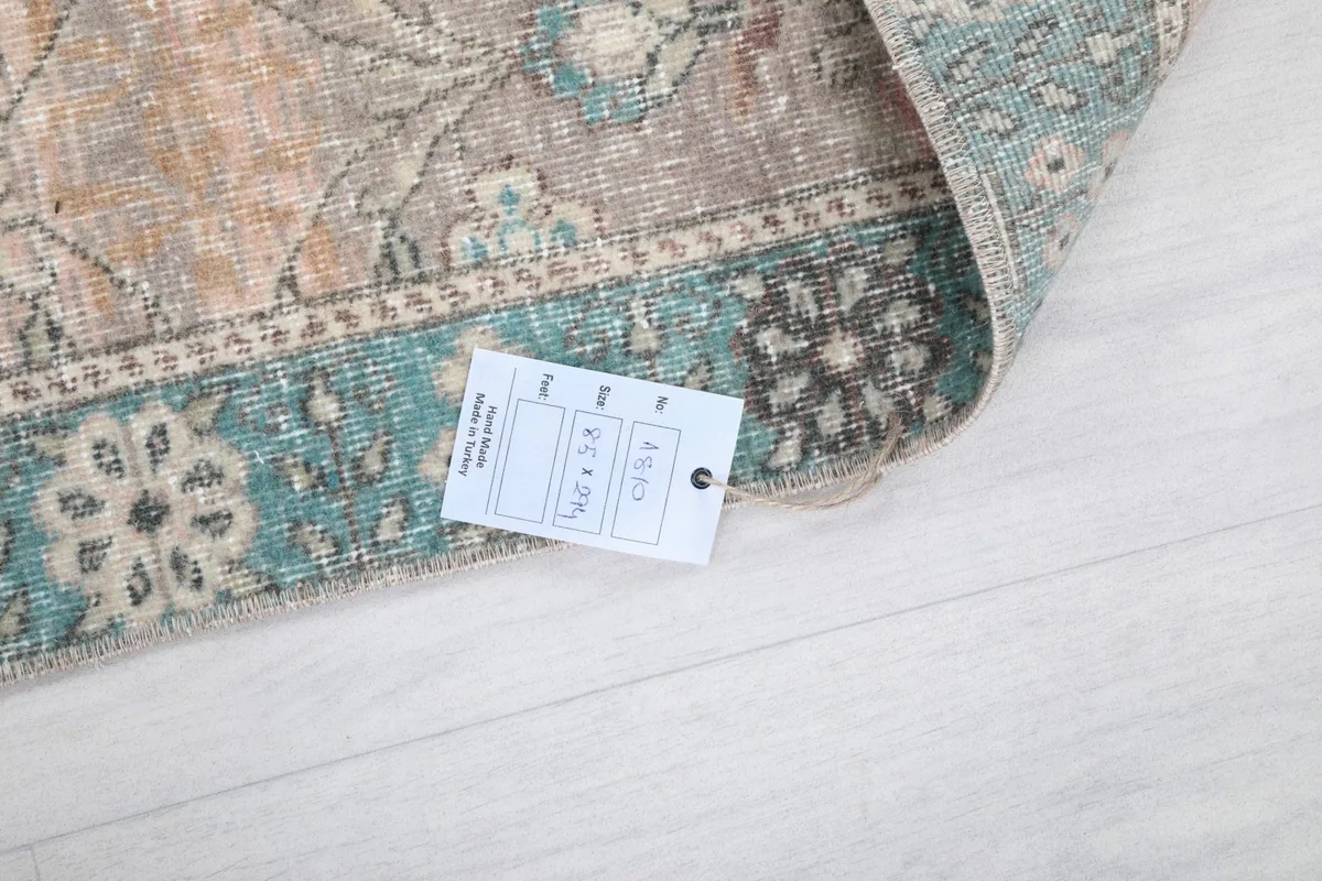 Corner of the rug with a product tag showing size and material information.