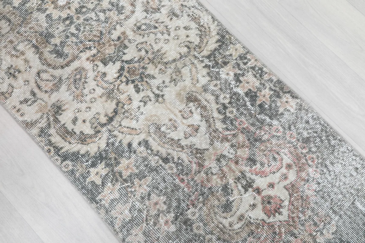 Angled view of the runner's surface, highlighting the distressed texture and motifs