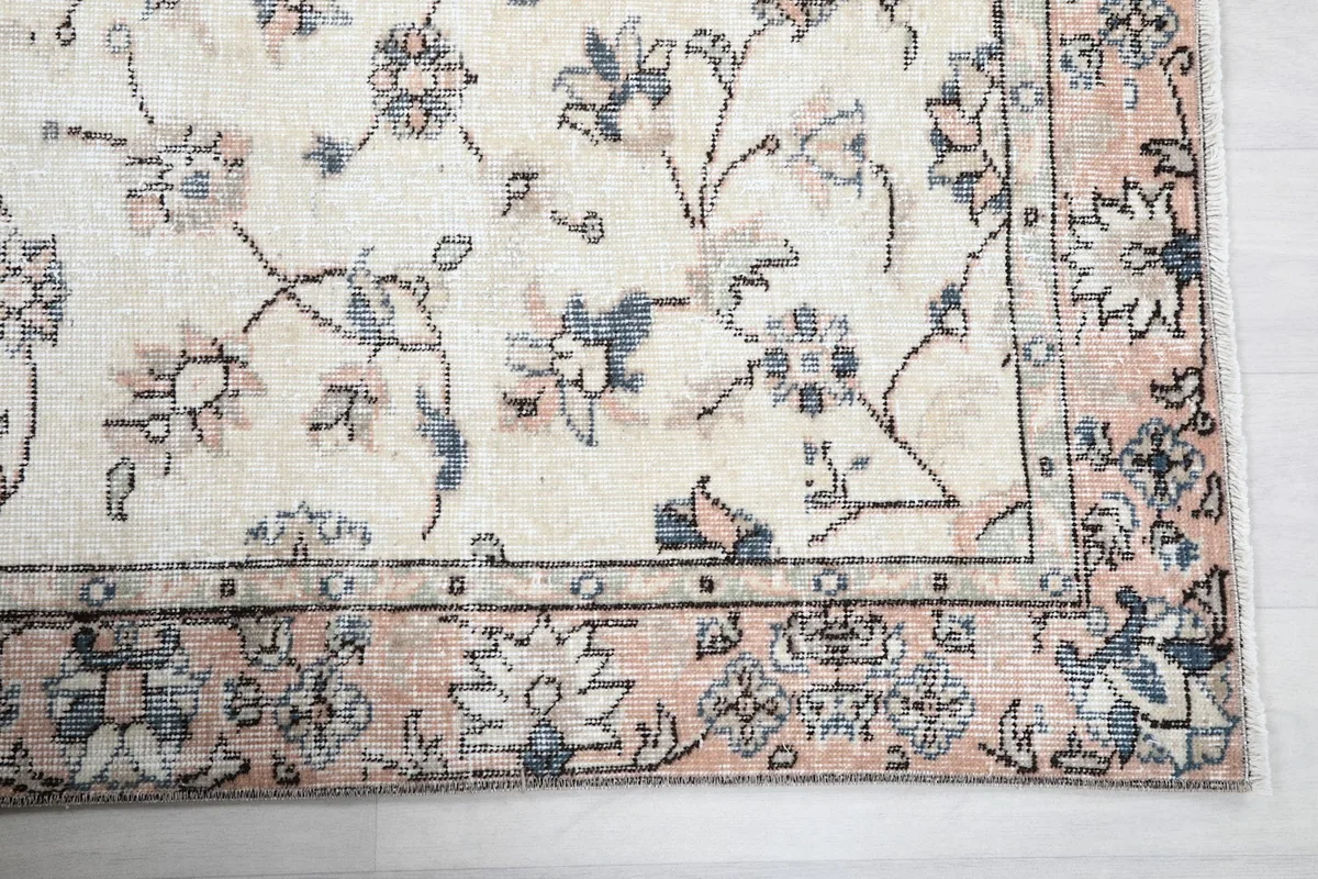 Detailed view of the corner of the rug, highlighting the rose border and intricate floral designs