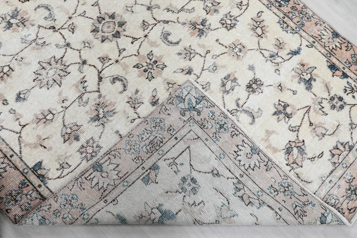 Underside view of the rug, revealing the cotton foundation and a glimpse of the hand-knotted construction