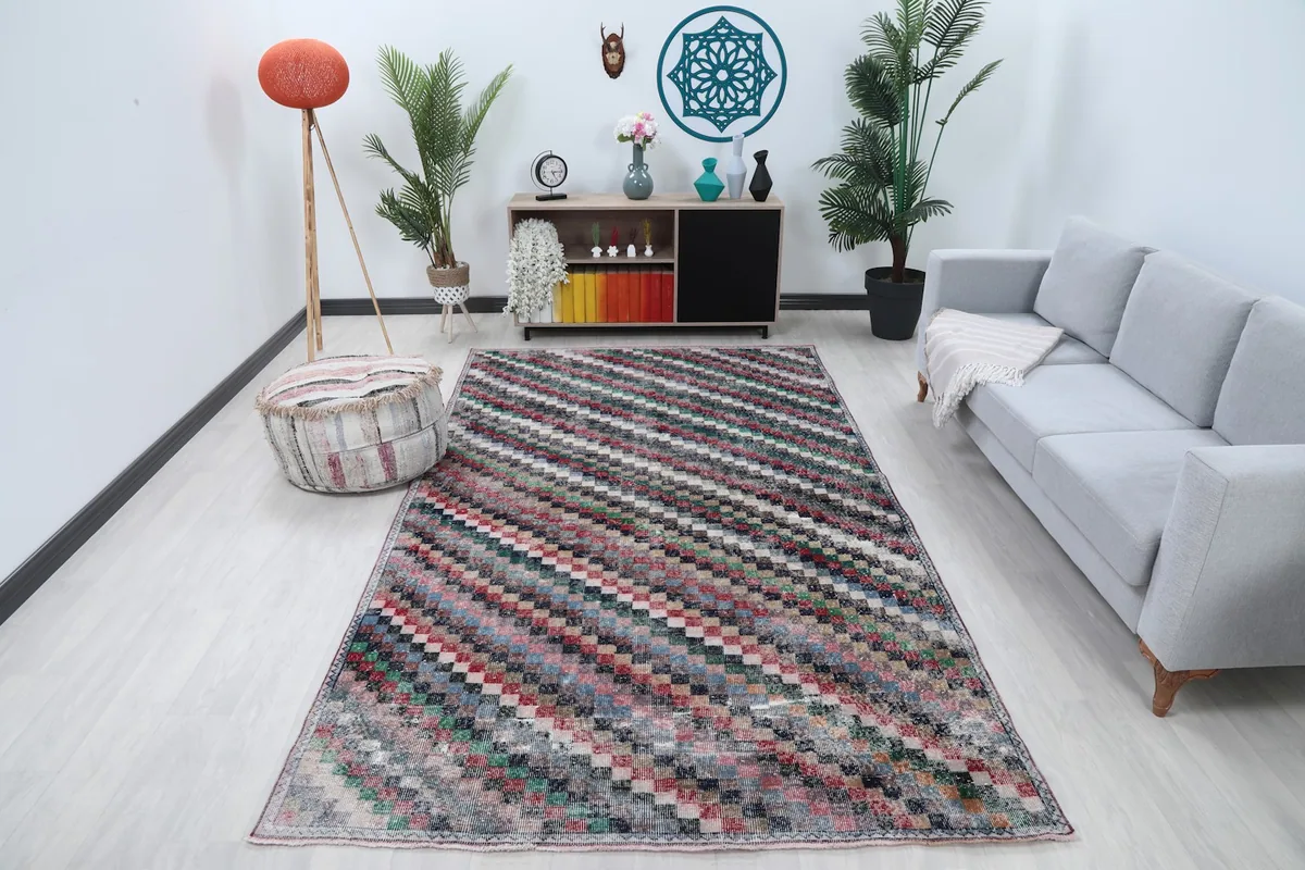 Vintage multicolor checkered rug displayed in a bright living room setting with a gray sofa