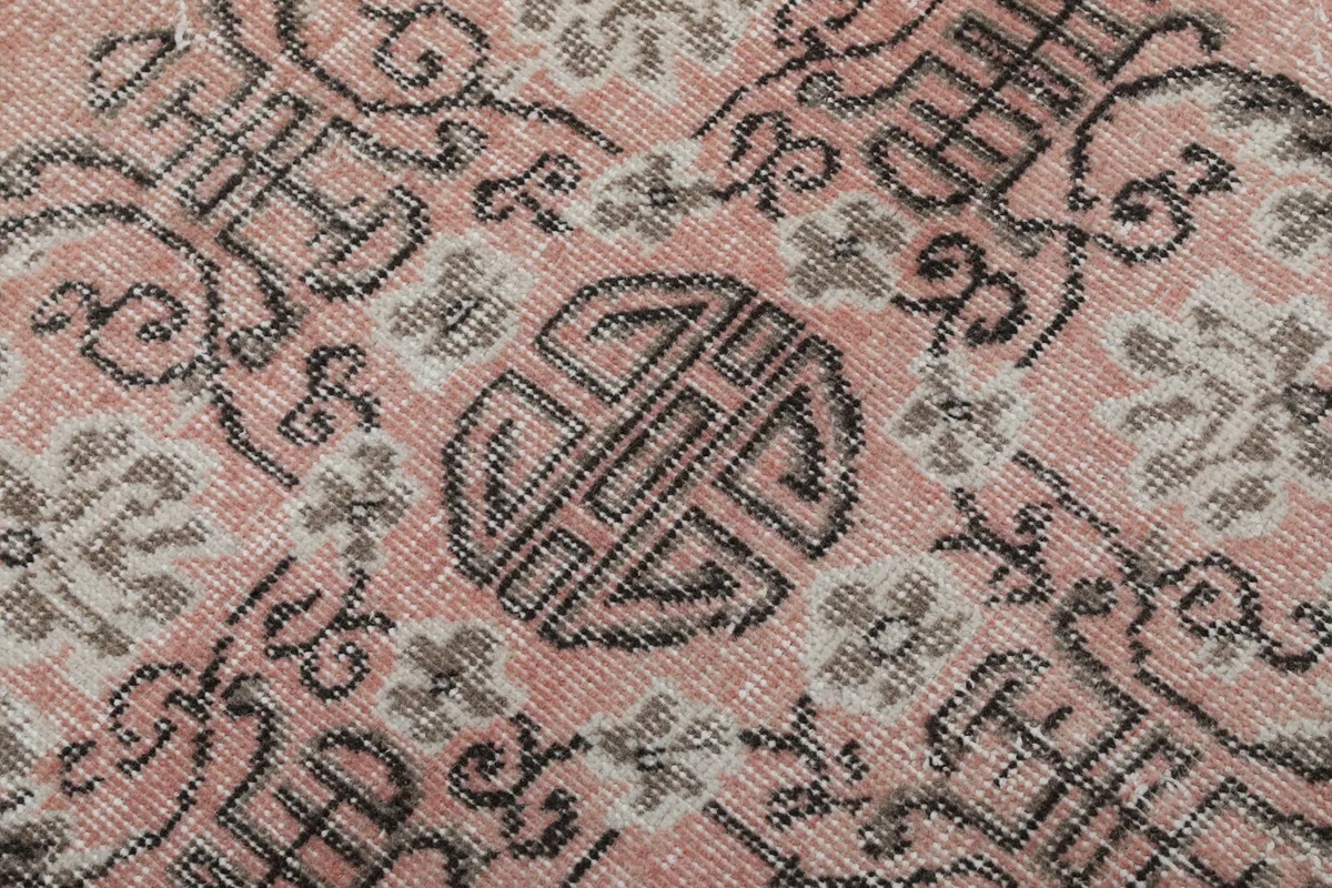 Extreme close-up of the central medallion's gray and charcoal knotting and intricate design