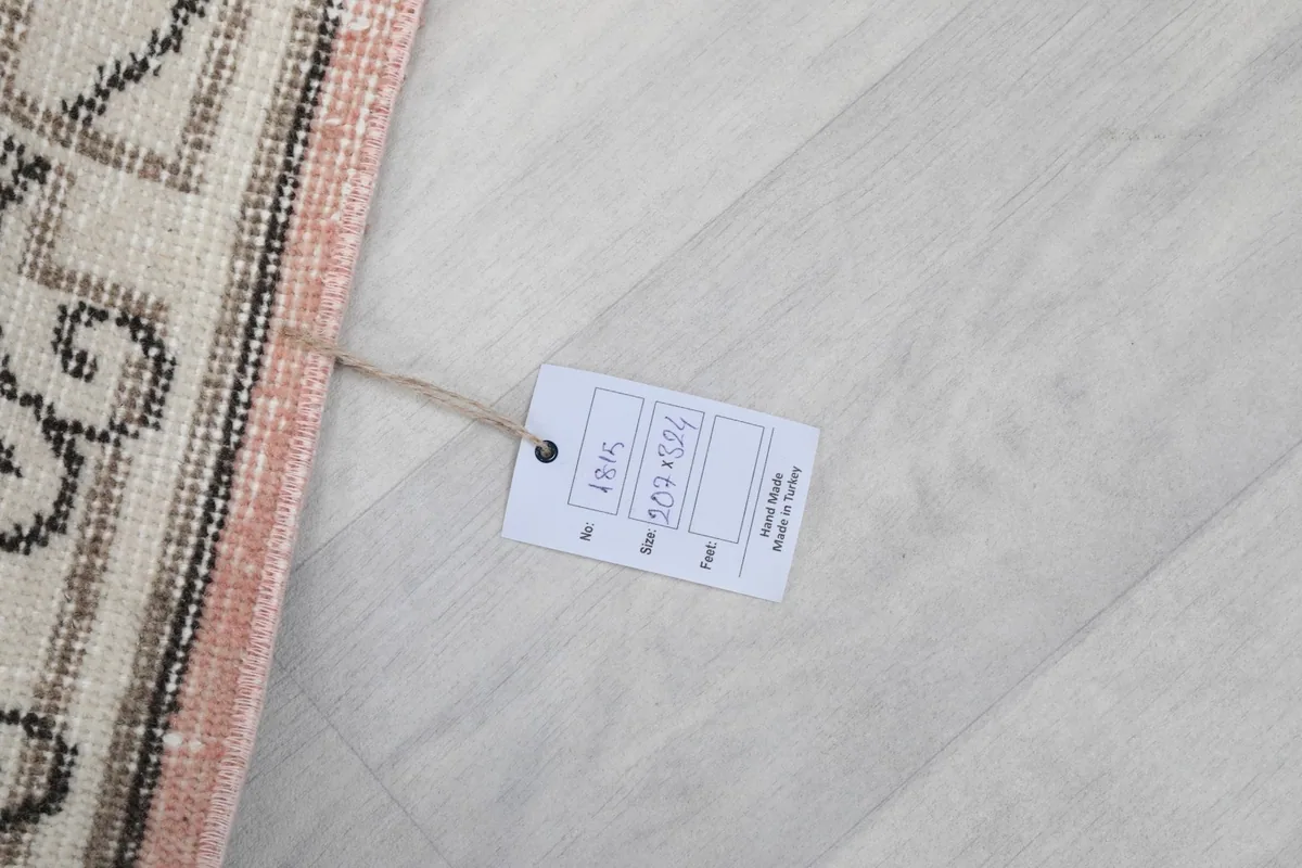 White tag attached to the rug, displaying its size and origin information