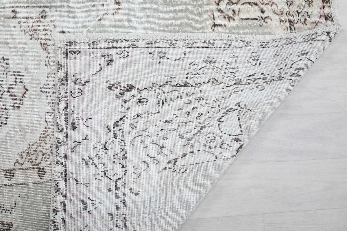 Corner of the rug turned over, showing the back and the structure of the weave