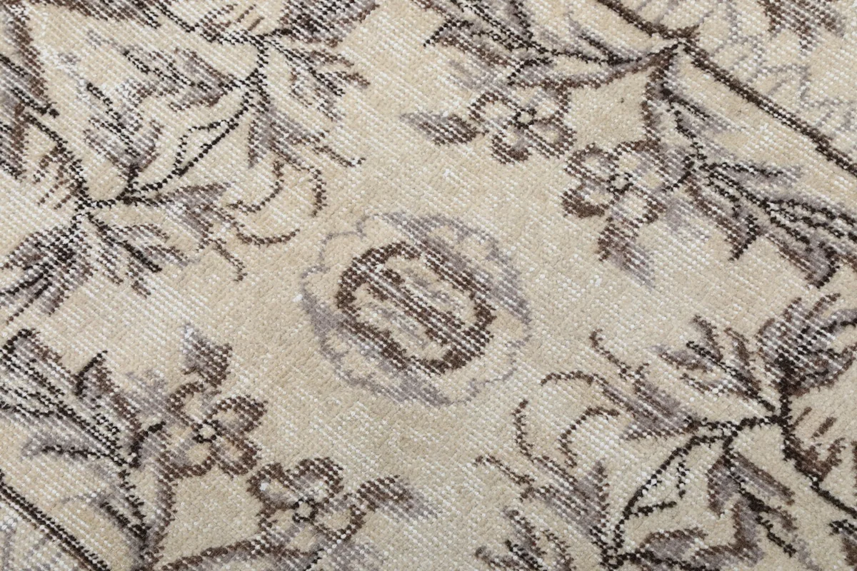 Extreme close-up showing the texture of the low wool pile and faded gray patterns