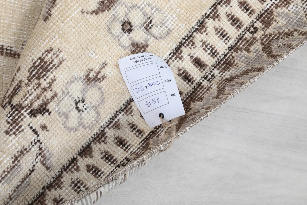 Folded corner of the rug with product tag showing dimensions and origin