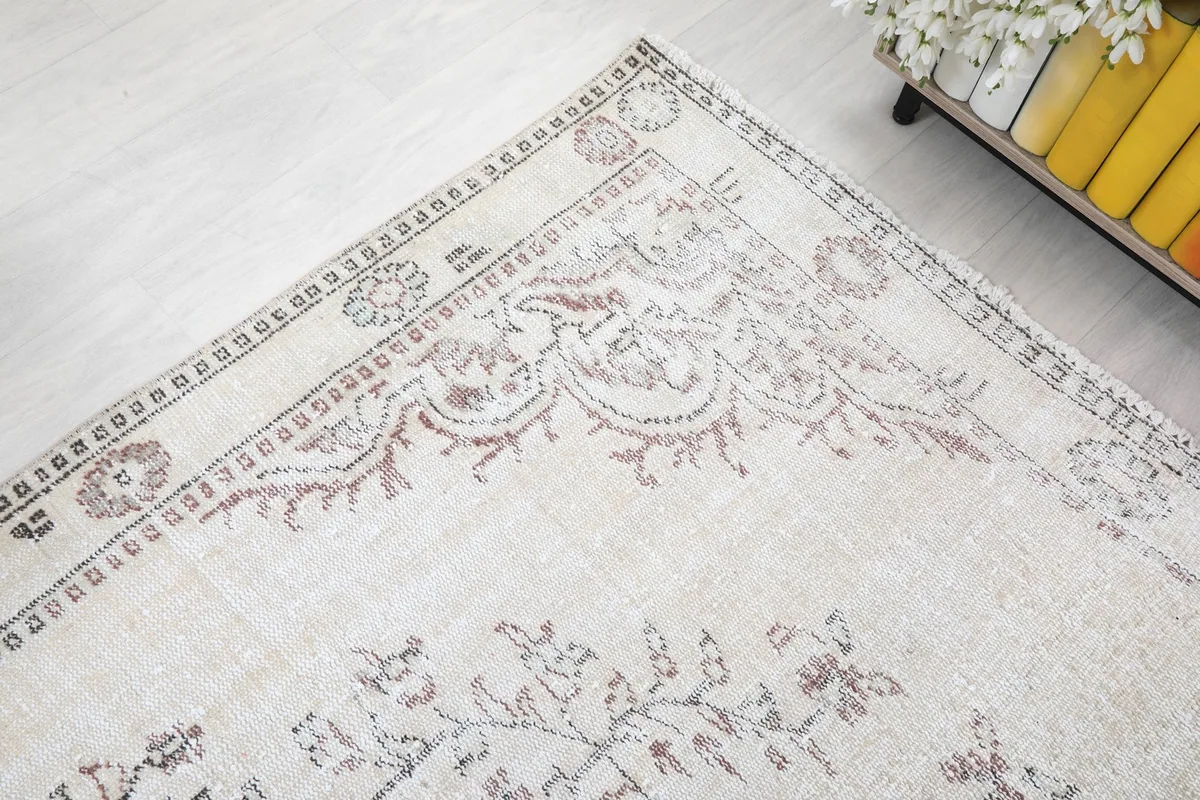 Corner view of the rug's border, revealing the intricate patterns and natural patina