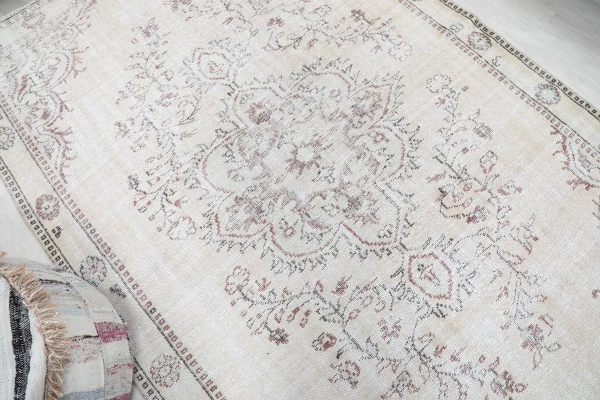 Close-up of the central medallion and surrounding floral patterns on the vintage rug