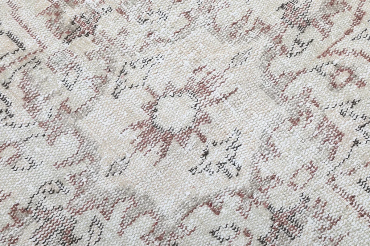 Extreme close-up showing the low pile texture and distressed details of the hand-knotted wool