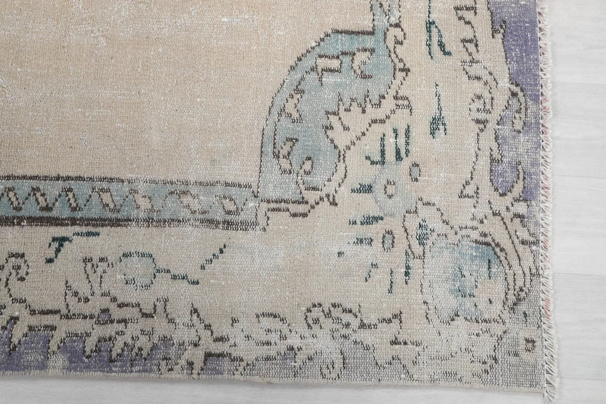 Detailed view of the corner motif and subtle purple and blue tones in the border