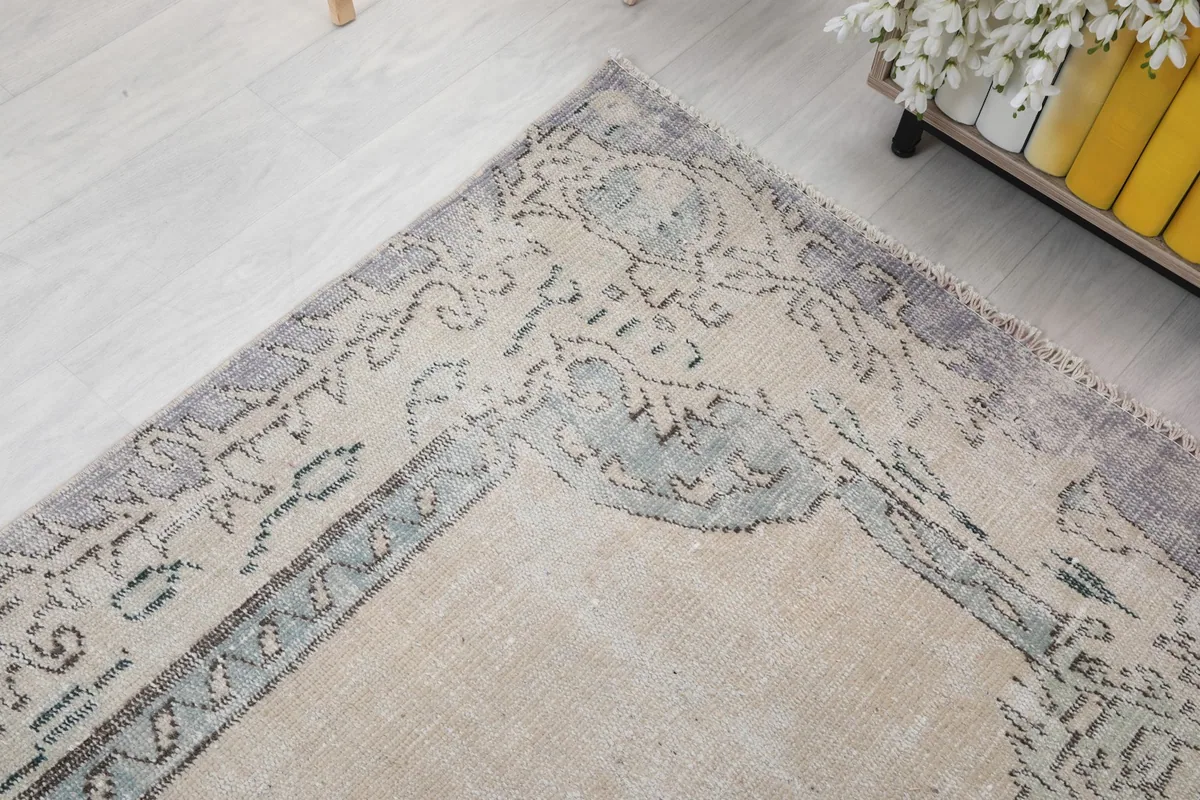 Corner detail of the rug showing the faded blue and purple border design