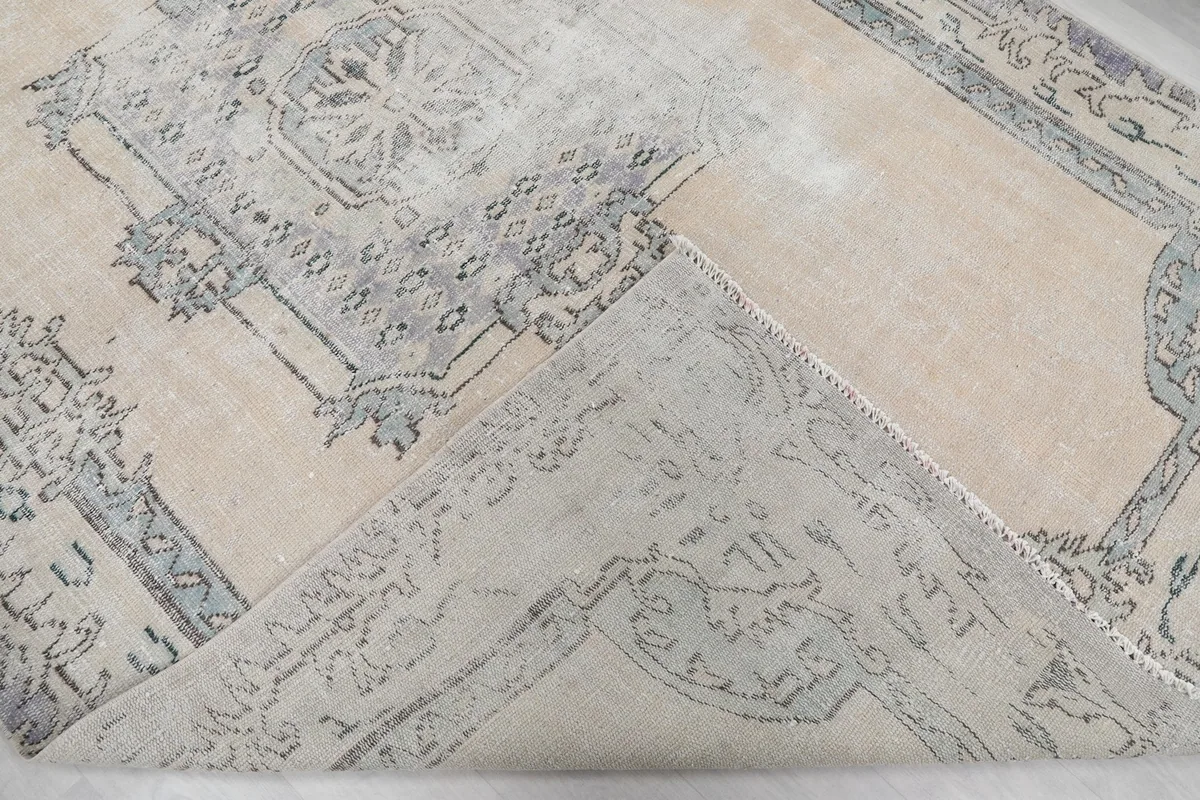 View of the underside of the hand-knotted wool rug, showing its cotton foundation