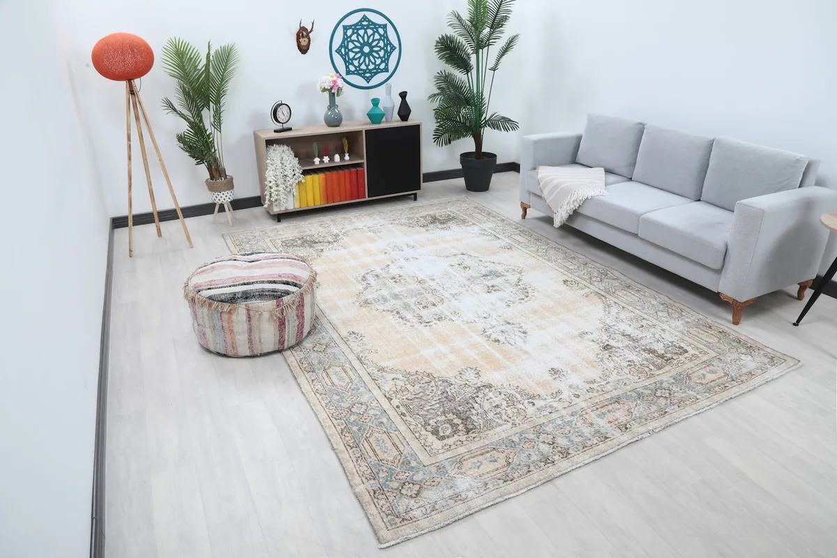 Overhead view of the large area rug in a living room with a sofa and pouf