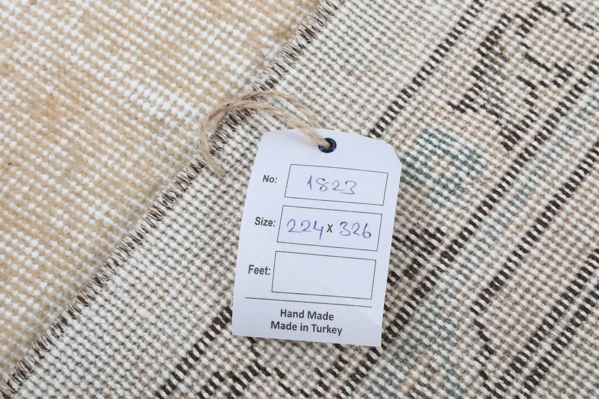 Back of the rug with a size tag, showing the hand-knotted wool pile on cotton foundation
