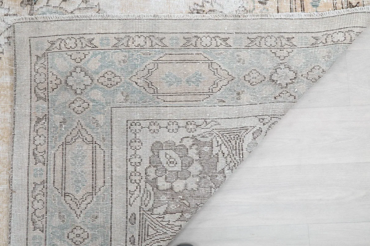 Folded corner showing the rug's sturdy construction and the reverse of the border design