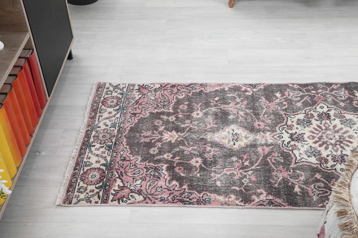 Angled view of the runner rug from the side, showcasing its full pattern and distressed look