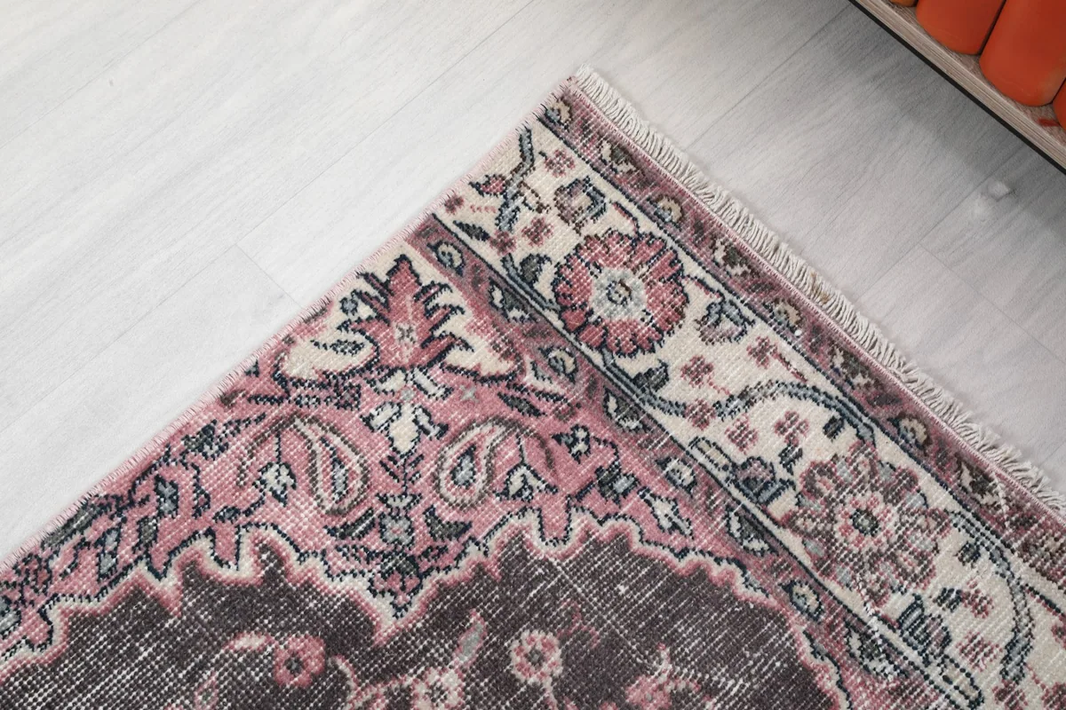 Close-up of the runner's top border and corner, showing the intricate rose and ivory pattern