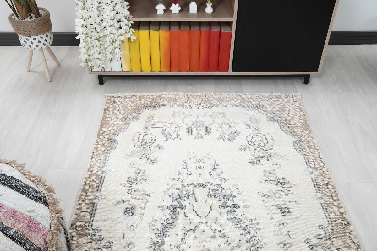 View of the rug from one end, showing the full length of the ivory field and brown border