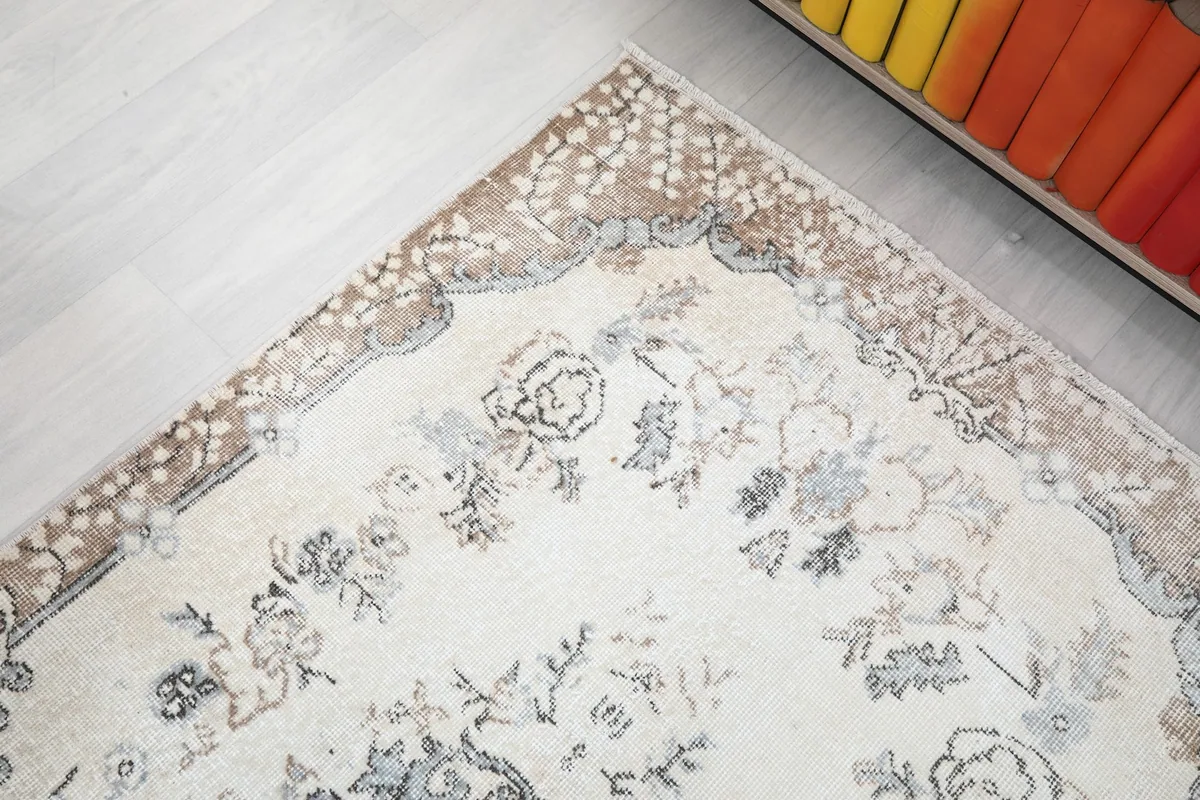 Close-up of the rug's border design, revealing the intricate patterns and brown tones