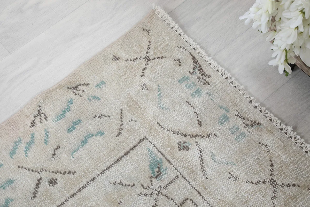 Corner detail of the rug, highlighting the soft blue and gray colors in the design