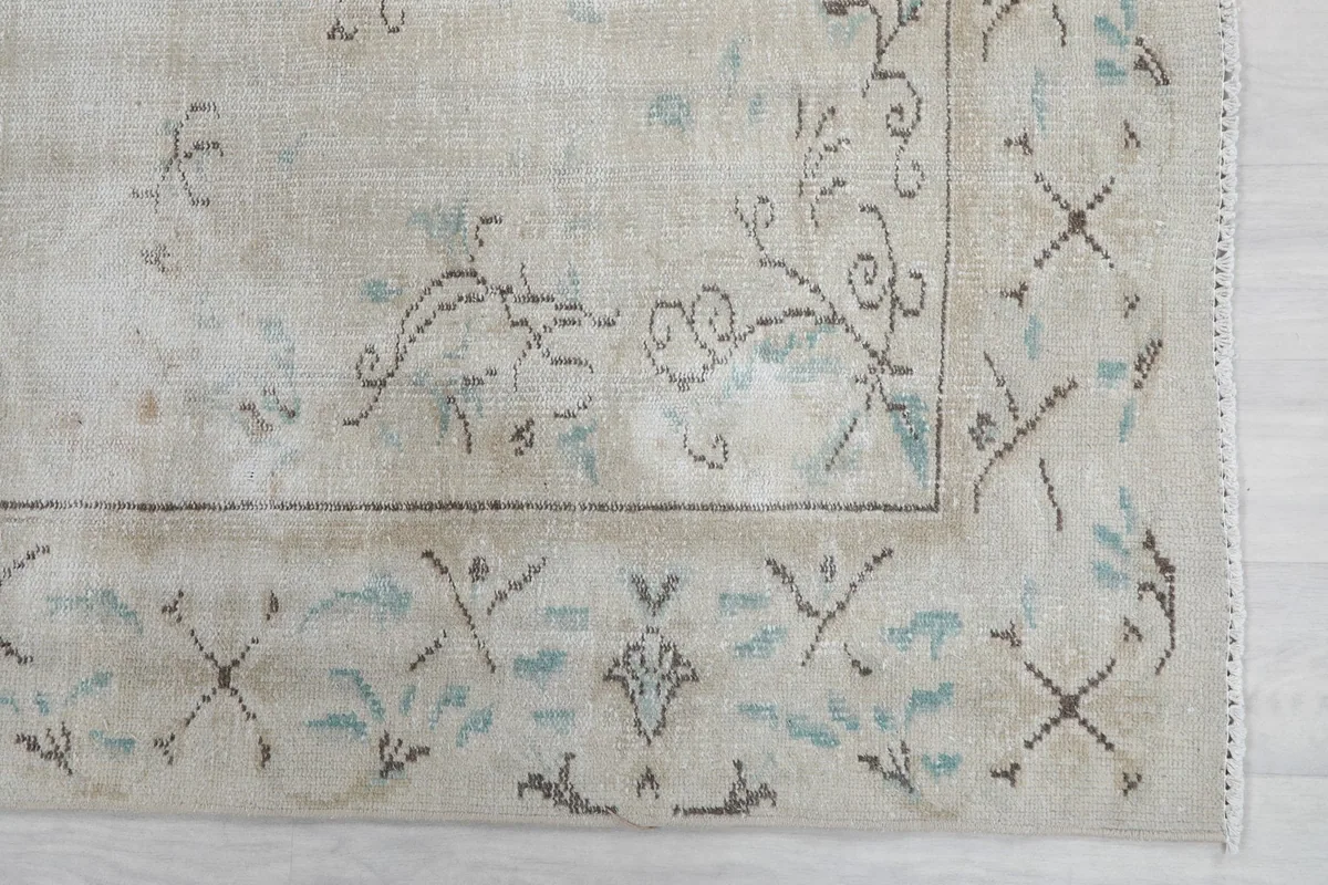 Detail of the rug's border design with blue and gray floral patterns