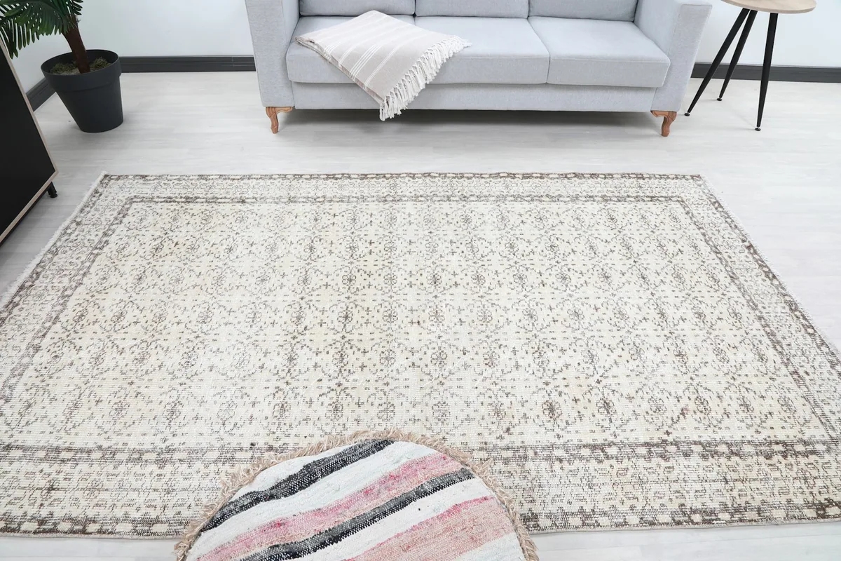 Frontal room view of the vintage rug, highlighting its full design and subtle color palette