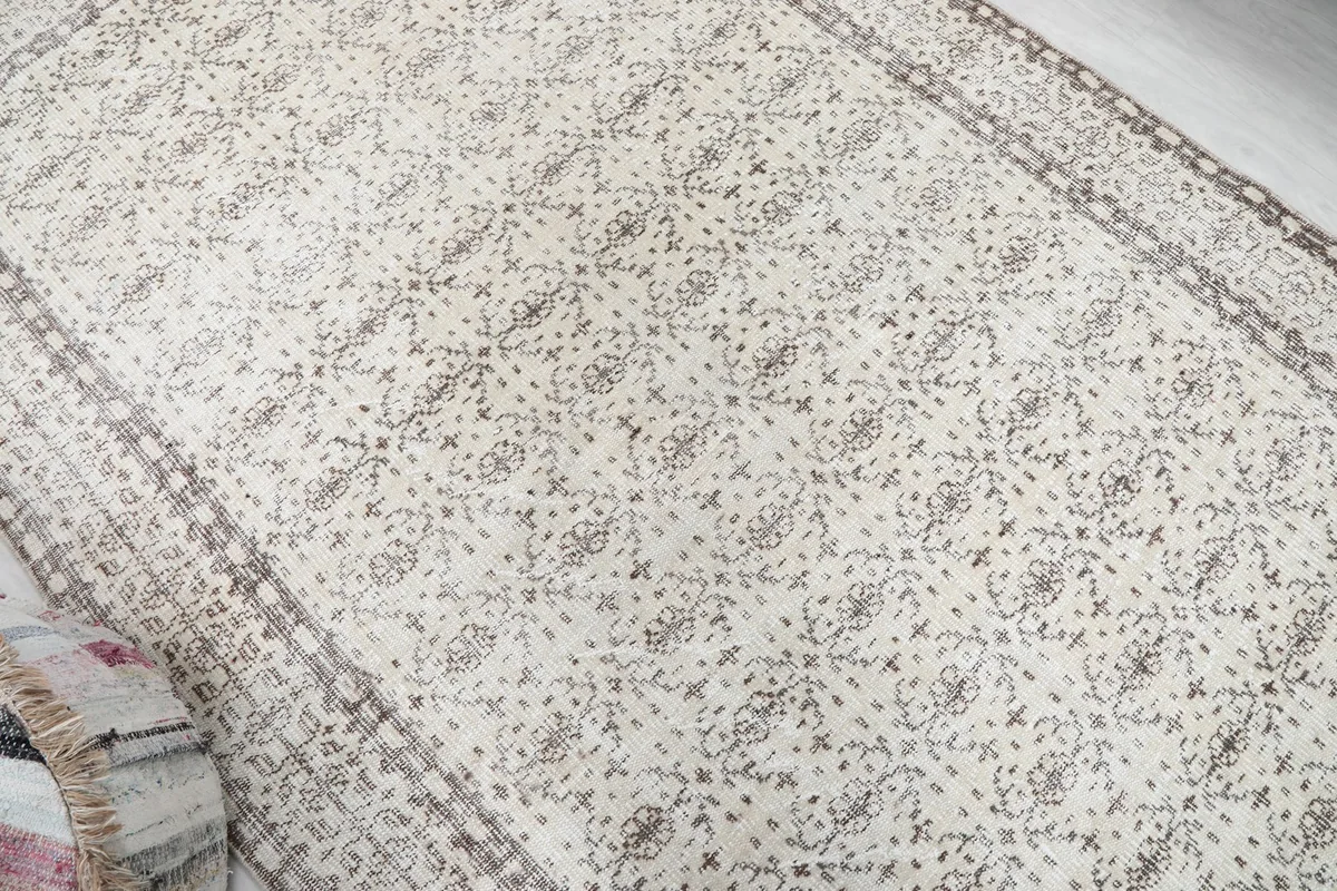 Overhead view showing the full pattern of the ivory rug with gray and brown accents