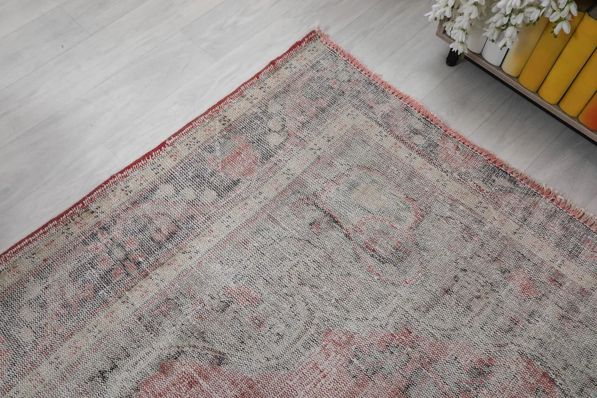 Corner view of the rug, showing the faded geometric patterns and soft color transitions.