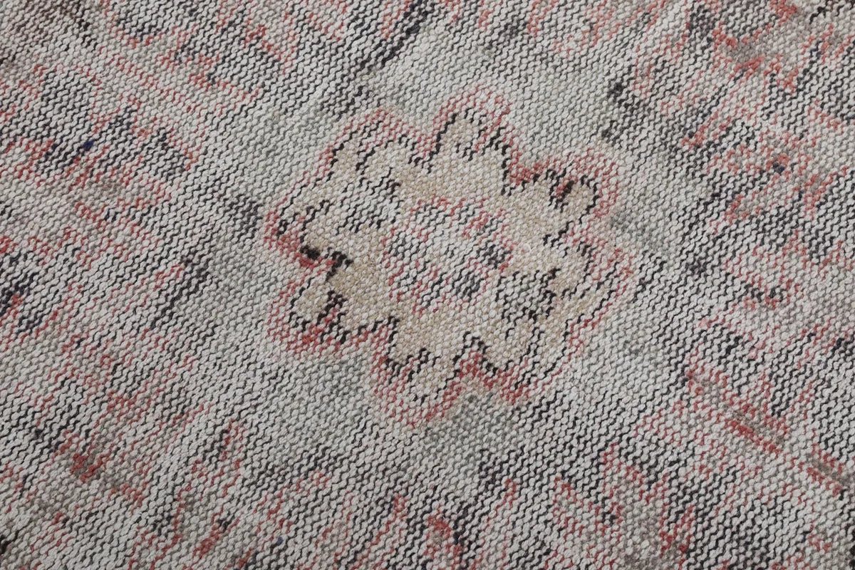 Extreme close-up view of the hand-knotted wool pile, showing the intricate weave and faded colors.