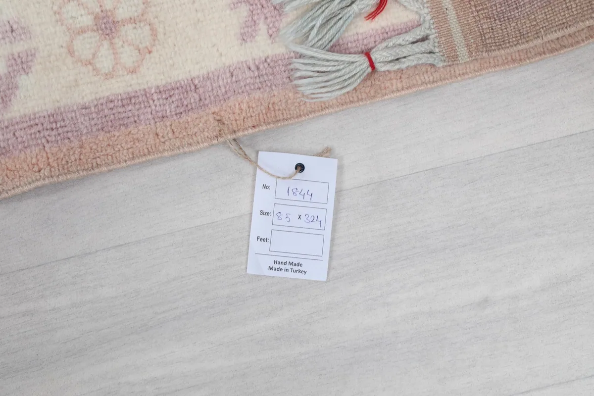 Photo showing the product tag attached to the rug, with size information 85 x 324 cm visible.
