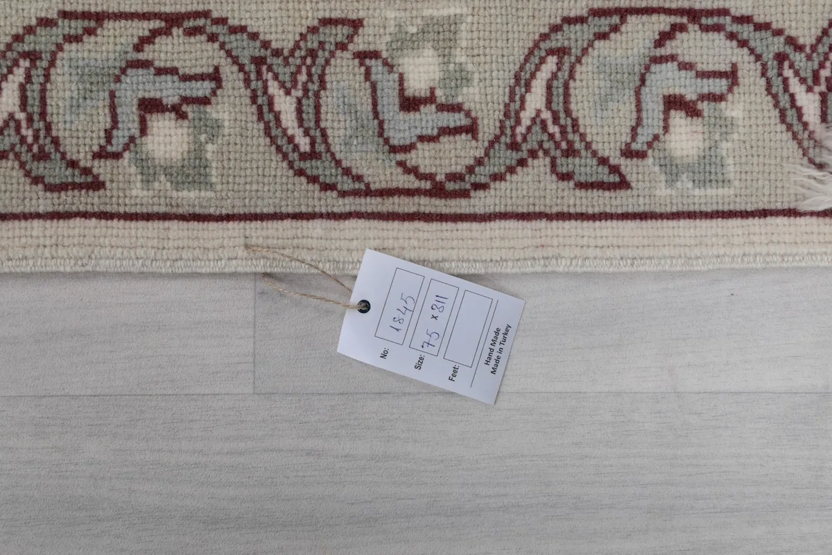 Close-up of the rug's label with size information (75 x 311 cm) and origin.