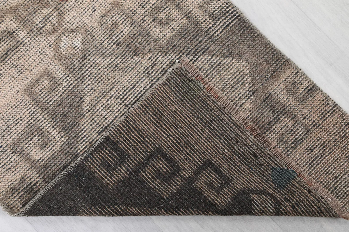 Folded corner revealing the cotton foundation and the reverse side of the hand-knotted rug.