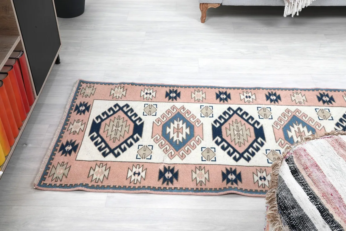 Angled view of the runner rug on the floor, extending towards a seating area
